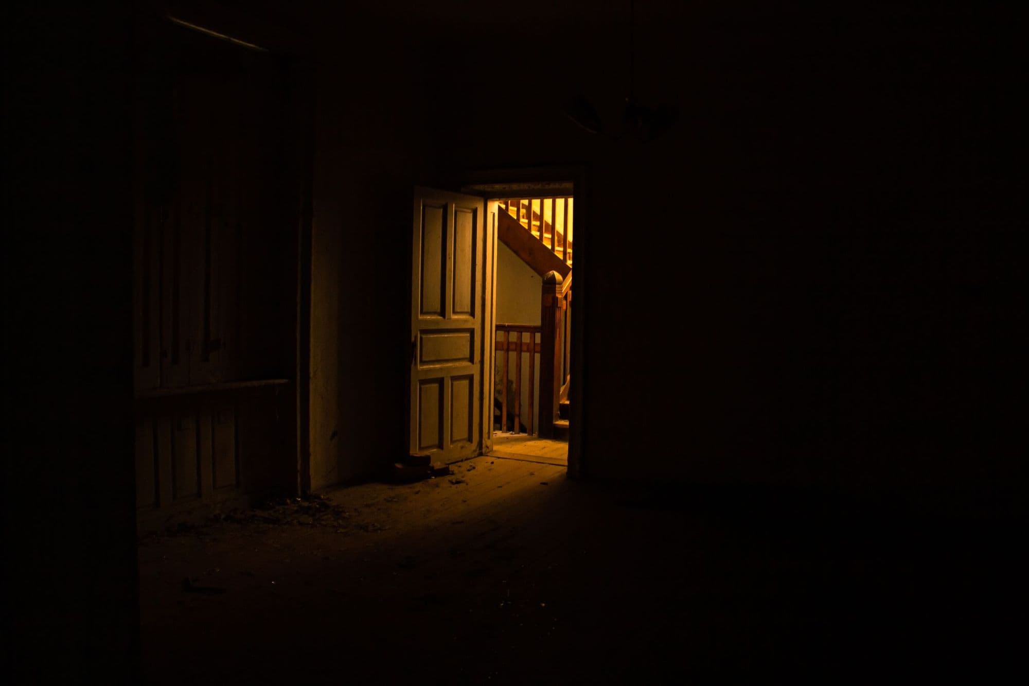 An open door with warm light spilling onto a staircase
