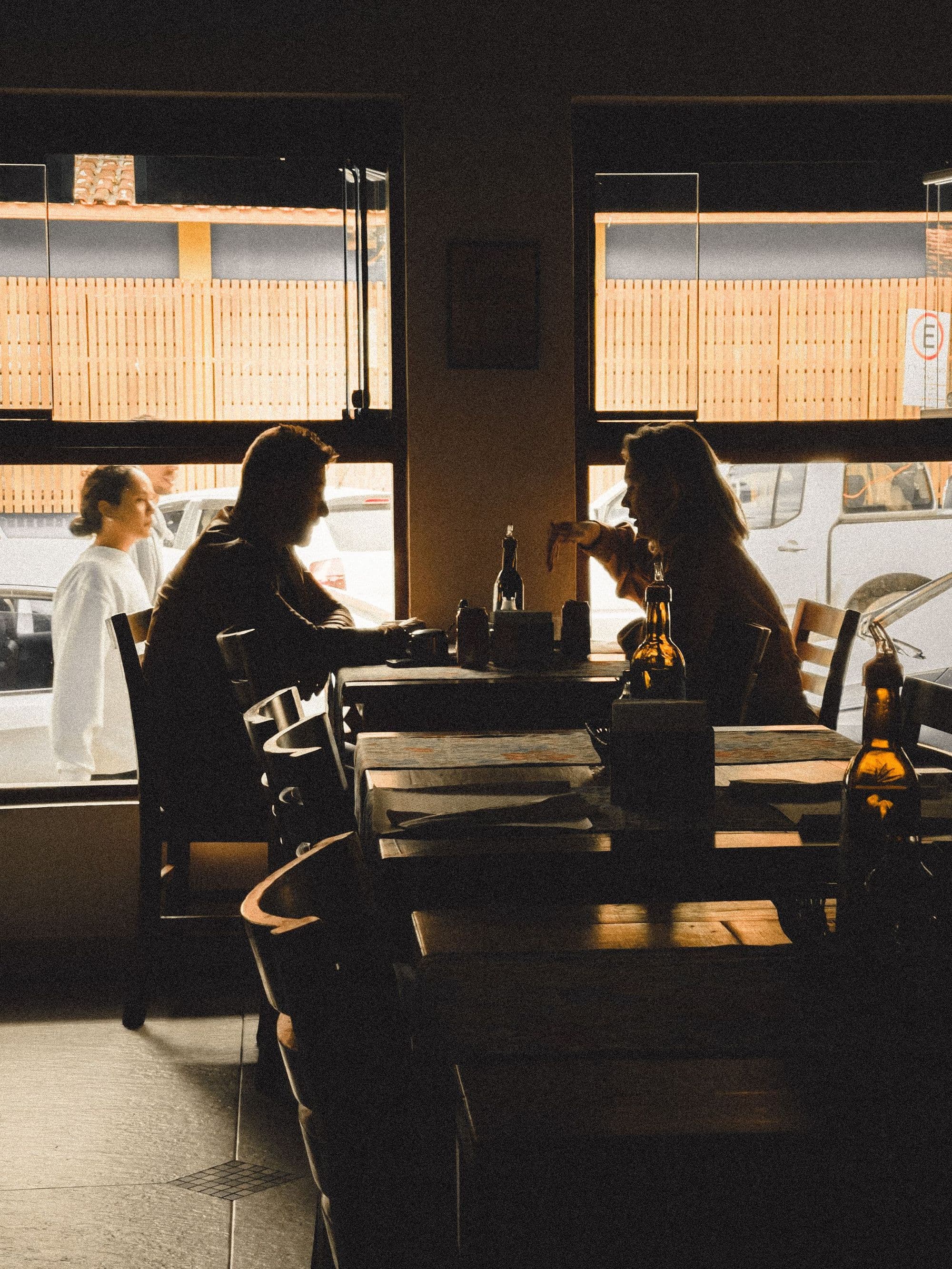 Two people deep in conversation at a table by a window