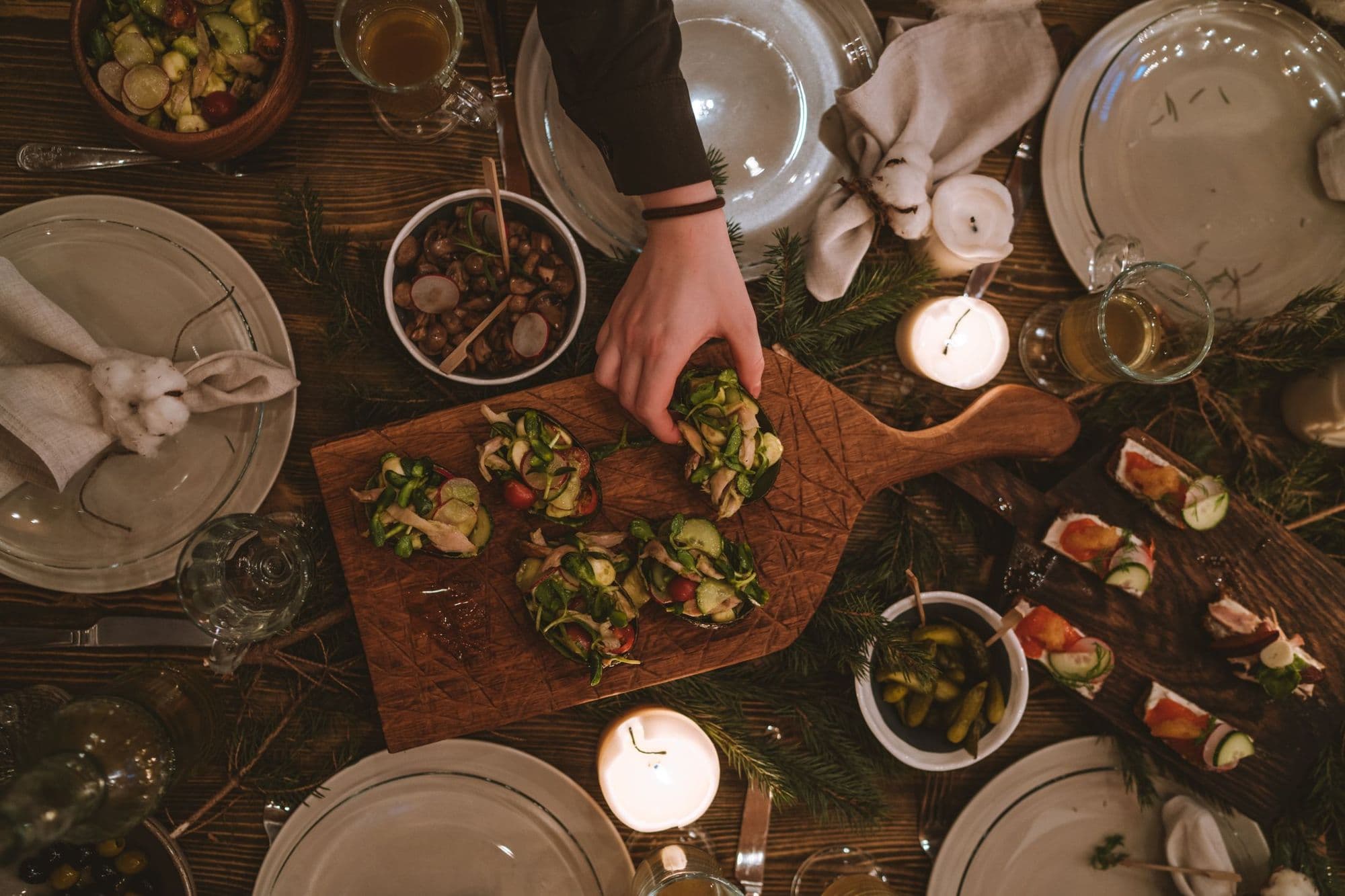 Hands reaching across a table set for dinner