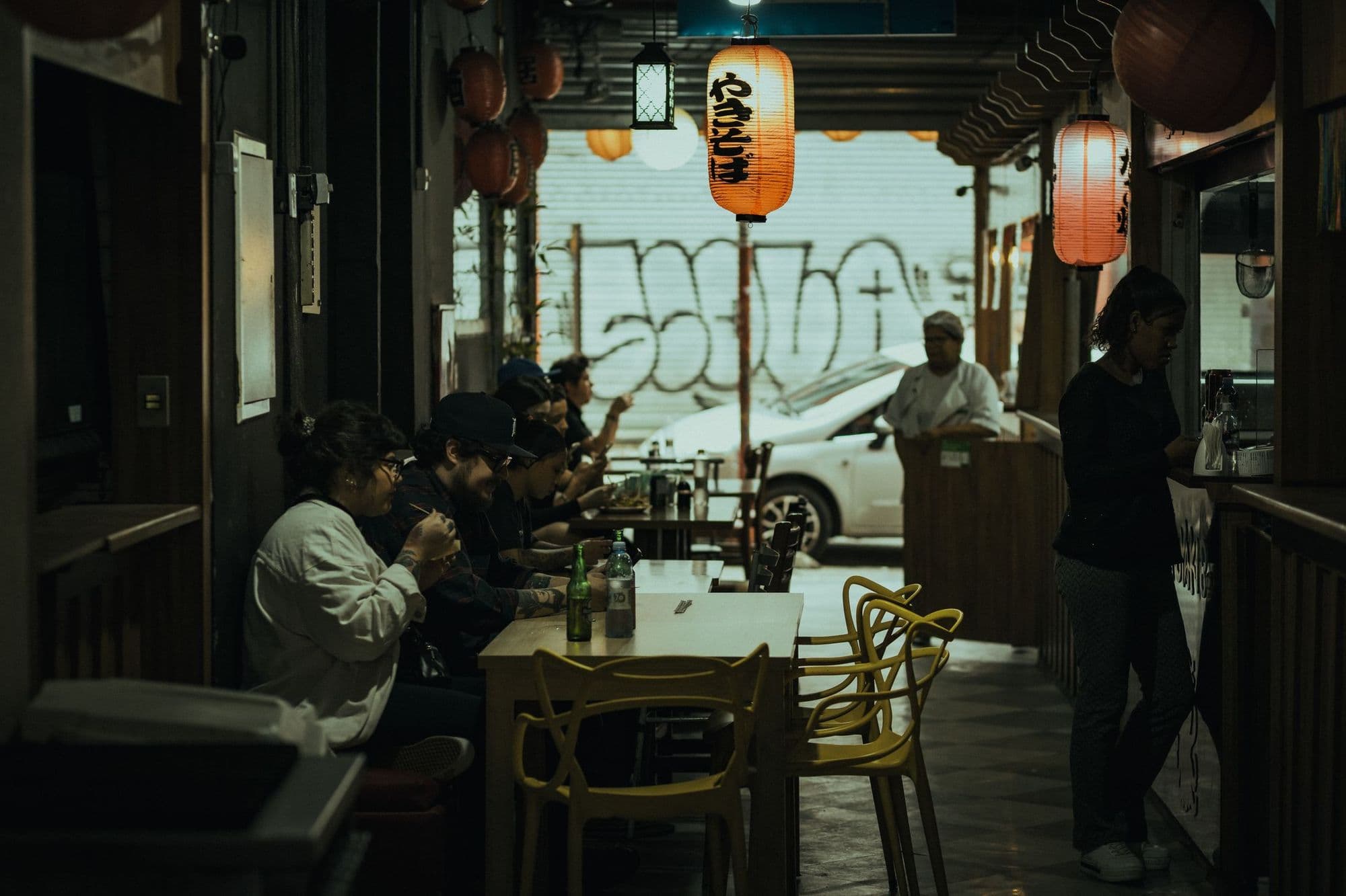A restaurant at night with members gathered under lanterns