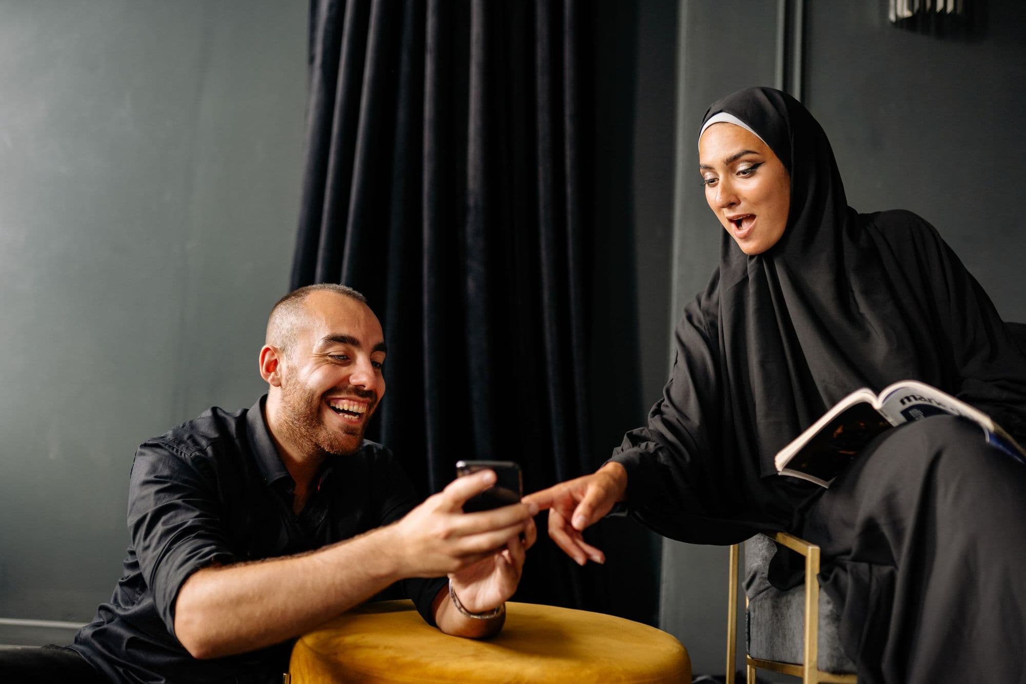 Two founders sharing something on a phone and laughing