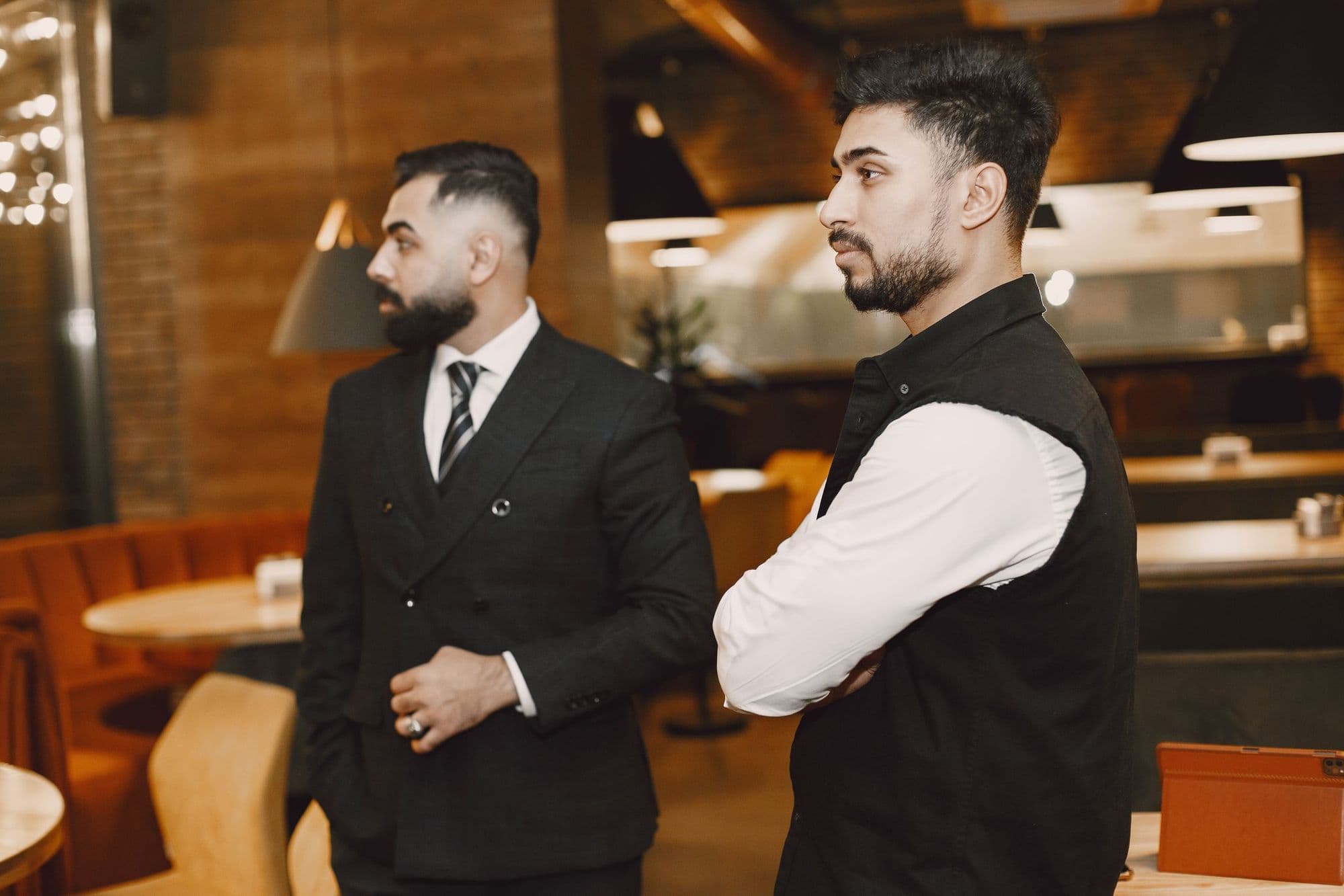 Two men in conversation in a warmly lit restaurant